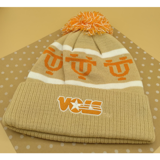 Knitted beanie with orange accents on a beige background