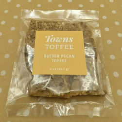 Packaged toffee with a gold label on a polka dot background